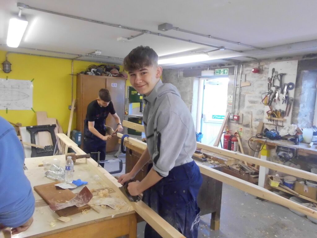 Banff Academy pupils boat building in the sea school workshop.
