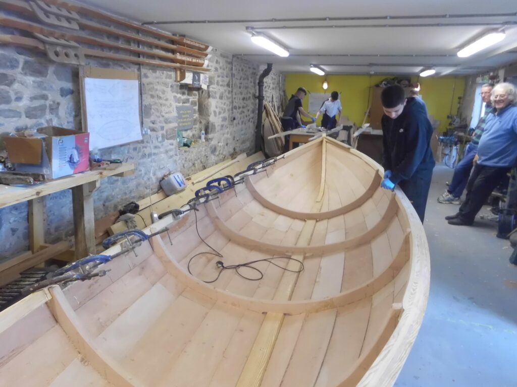 Banff Academy pupils boat building in the sea school workshop.