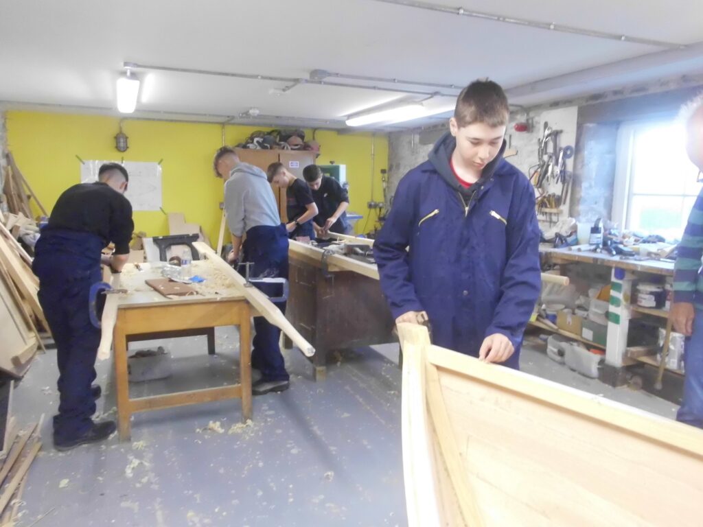 Banff Academy pupils boat building in the sea school workshop.
