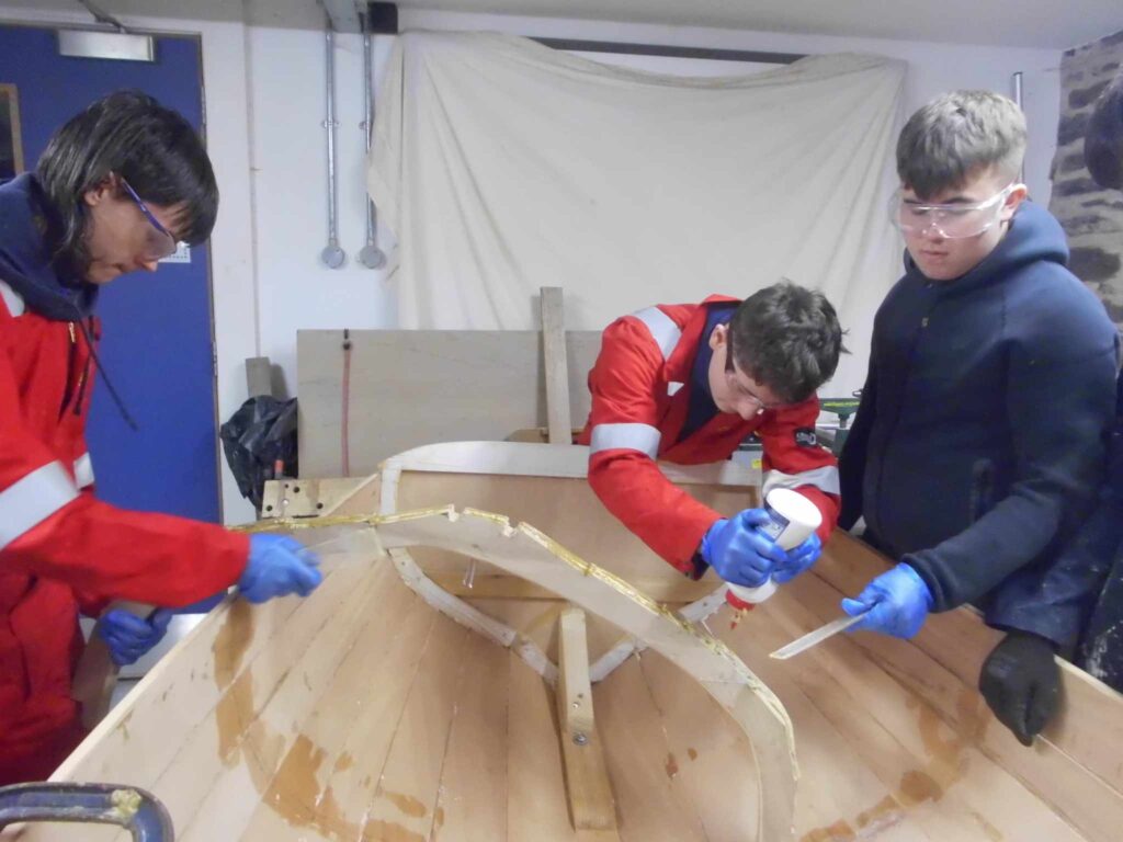 Image of Banff Academy pupils in the boat building workshop at Cullen Sea School
