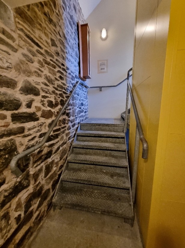 Image showing first part of steel staircase that leads from ground floor to mini-landing with right turn leading to final part of staircase.