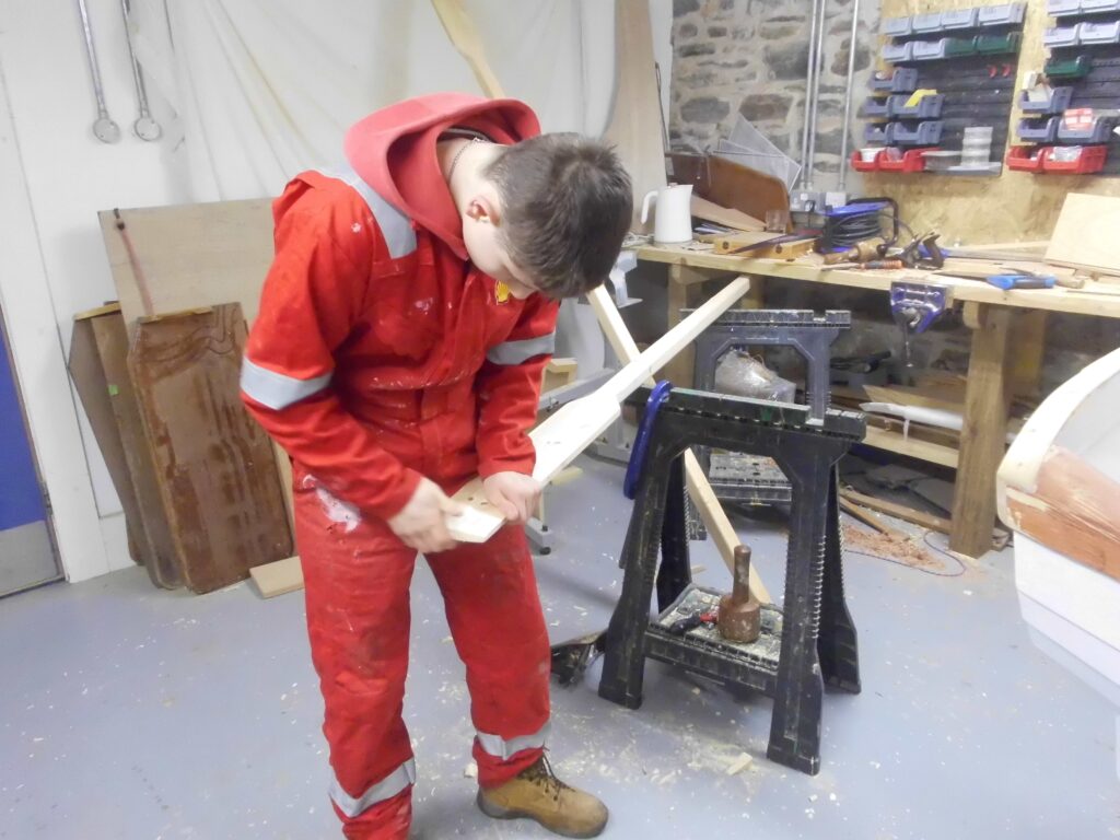 Image showing a Banff Academy pupil boat building in the sea school workshop