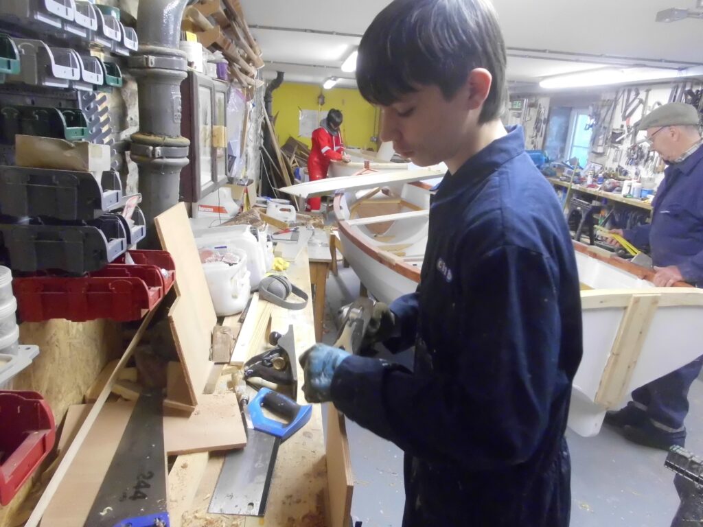 Image showing a Banff Academy pupil boat building in the sea school workshop